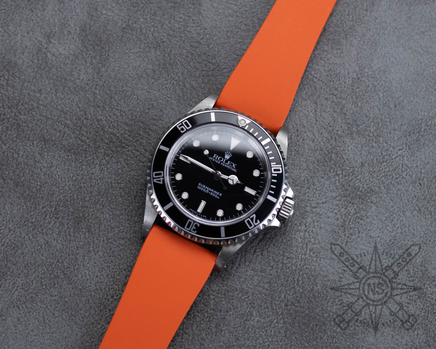 Orange rubber watch strap on a Rolex Submariner