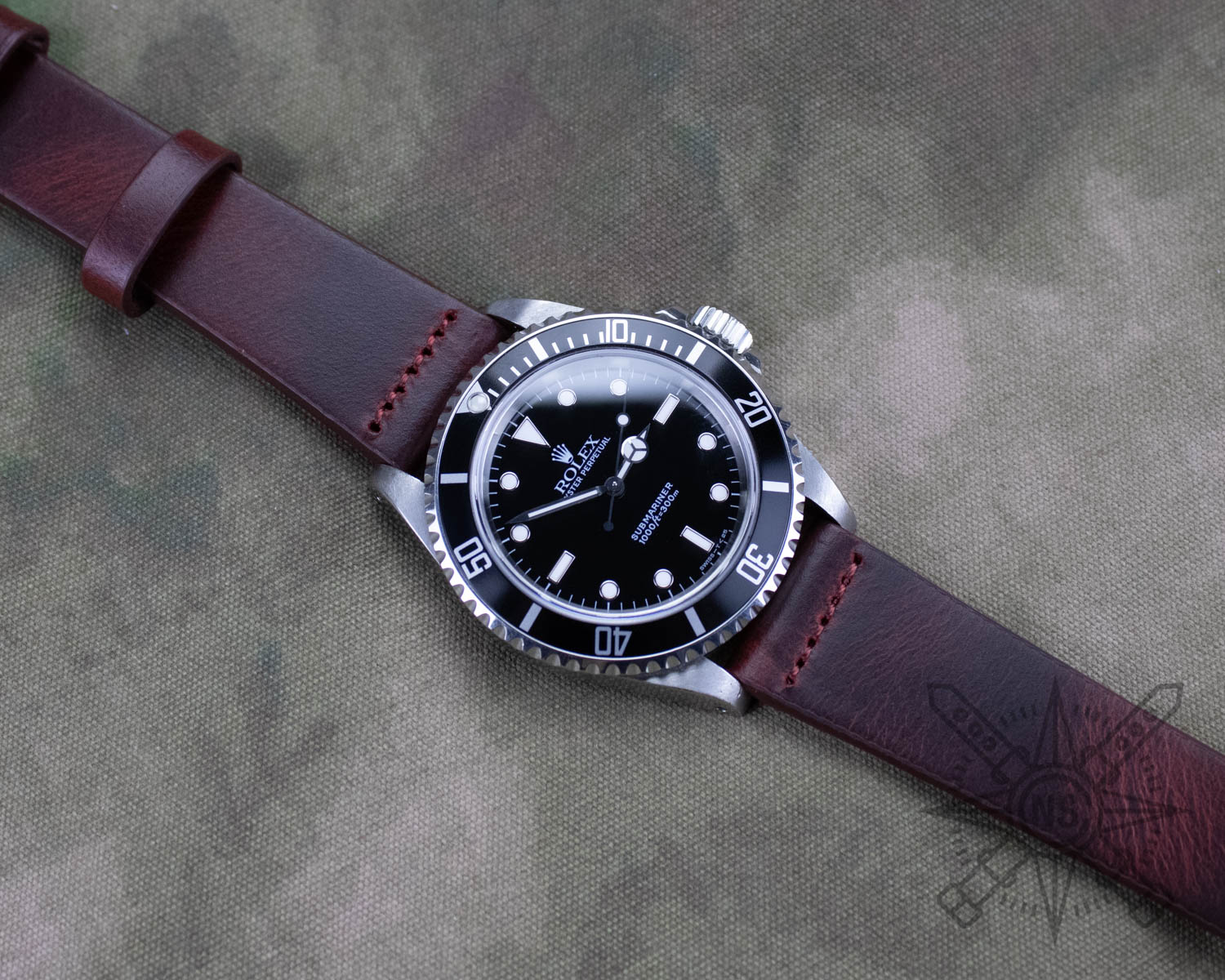 Burgundy red row-stitched leather watch band on a Rolex Submariner
