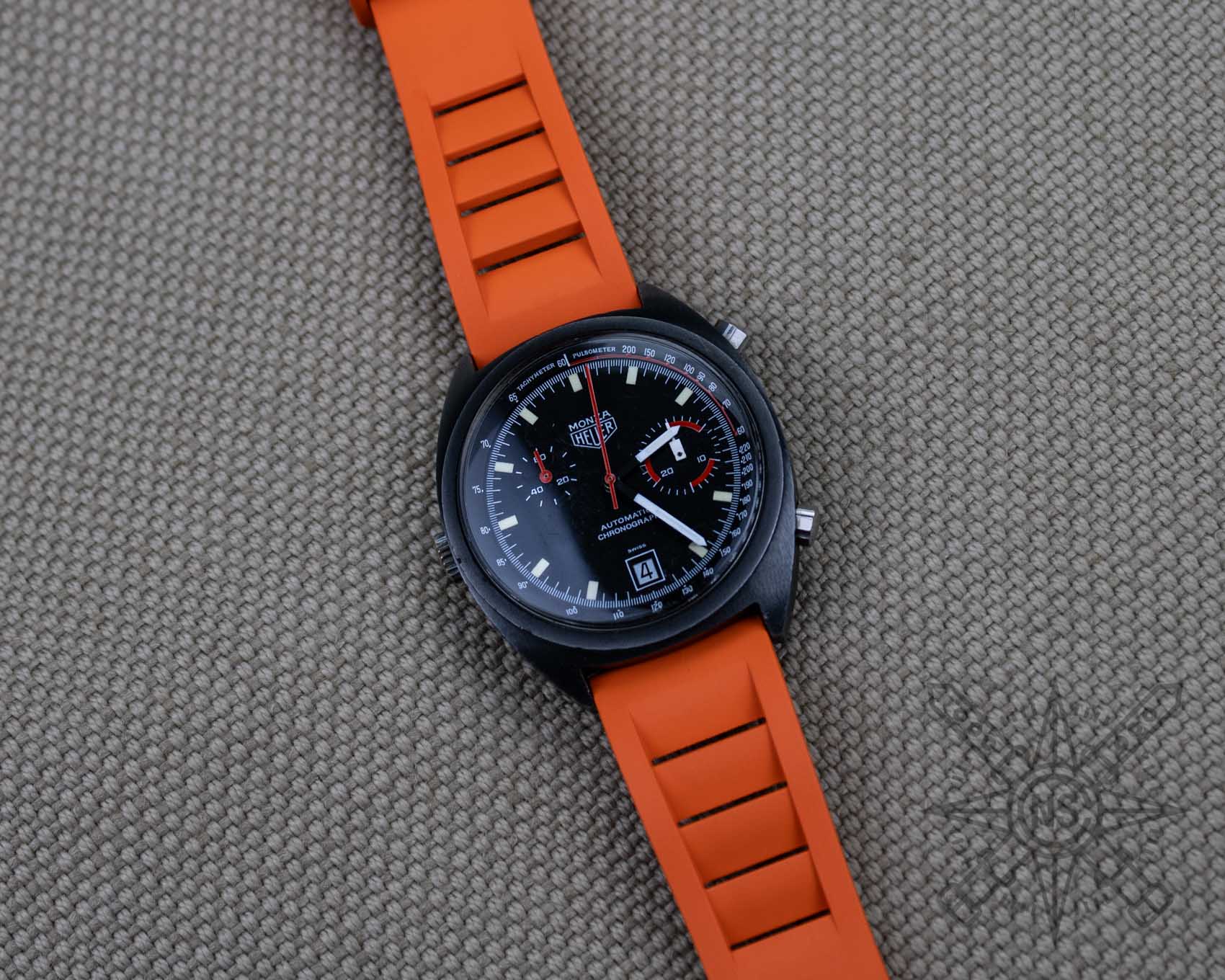 Orange rubber watch strap on a vintage Heuer Monza